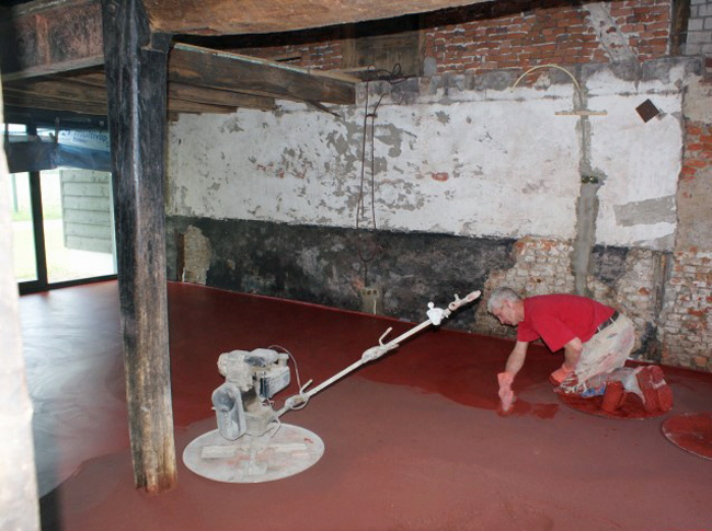 Volledig gekleurde ossebloed rode cementdekvloer welke voorzien wordt van een pleisterlaag.